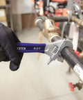 2-In-1 Reversible Adjustable And Pipe Wrench with Extra Wide 1-1/2 Inch Jaw used on pipe in plumbing setting