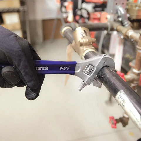 2-In-1 Reversible Adjustable And Pipe Wrench with Extra Wide 1-1/2 Inch Jaw used on pipe in plumbing setting