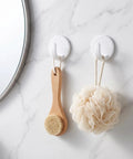 Eight Piece White Peel And Stick Wall Hooks Offer A Super Strong Hold That Skips The Drilling Headaches While Making Everyday Organizing Easy Peasy And Totally Damage Free For Any Room, holding a wooden brush and a loofah.