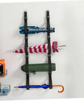Heavy Duty Adjustable Wall Storage Straps With Badass Rugged Buckles Perfect For Camping Chairs Yoga Mats And Tents securely holding umbrellas and gear on a wall.
