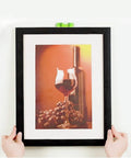 Hands hanging a picture frame using Heavy Duty Picture Hanging Strips 24 Pairs 48 Strips Removable Hook And Loop Mounting Tape