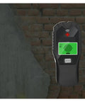Badass Precision 5 In 1 Stud Finder And Wall Scanner displaying on a brick wall, detecting wood, metal, and live wires.