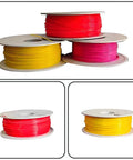 Assorted plastic filaments in red, pink, and yellow spools for Compact Desktop Filament Extruder And Maker Machine For 3D Printers.