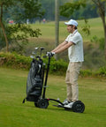 Electric Four Wheel Foldable Golf Cart Trolley With Easy Push Or Ride Options In Classic Black Trim on grassy golf course.