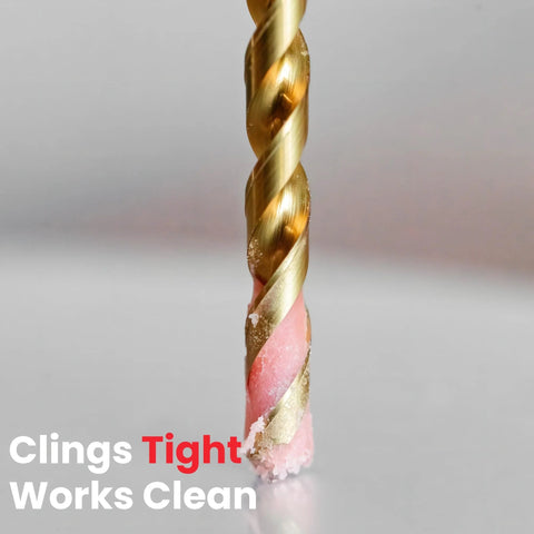 Drill bit coated with pink cutting paste for metal drilling; gold flutes visible
