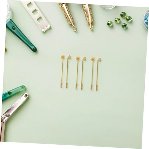 Vintage Copper Flat Round Tray Lapel Pins With Strong Penetration And Wirewrapped Capability For Jewelry Making Crafts And Daily Wear Style Blanks laid out among crafting tools on a green background.