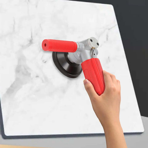 Side view of a red-handled 4-inch pneumatic wet stone polisher pressed against a marble slab.