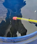 Hands-Off Manual Siphon Pump That Gets The Job Done Fast in a blue barrel, siphoning water with yellow hose and red end.