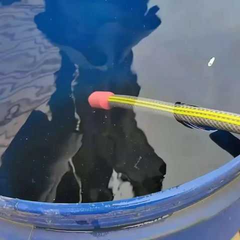 Hands-Off Manual Siphon Pump That Gets The Job Done Fast in a blue barrel, siphoning water with yellow hose and red end.