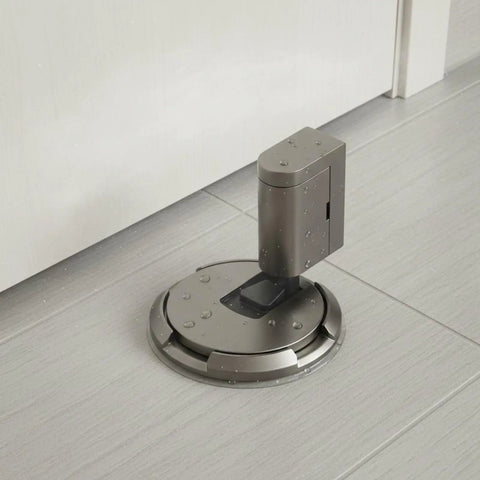 Solid Zinc Alloy Door Stopper With Suction Holder For Floor And Walls Holds Tight Against Wind To Keep Bedroom Office Quiet And Safe From Slams, installed on gray floor.