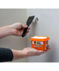Person applying Heavy Duty Wall Repair Spackling Plus Primer 16 Oz White Tub Patch Cracks Holes And Uneven Ceilings With Smooth Finish