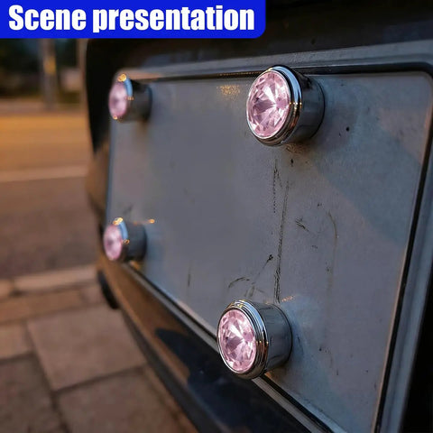 Fresh Pink Bling License Plate Screws 4 Pack shown on a license plate, showcasing rhinestone security bolt caps in daylight.