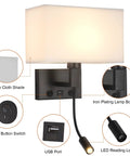 Detailed view of hardwired black wall sconce with USB port, reading lamp, linen shade, switches for bedroom and living room use.