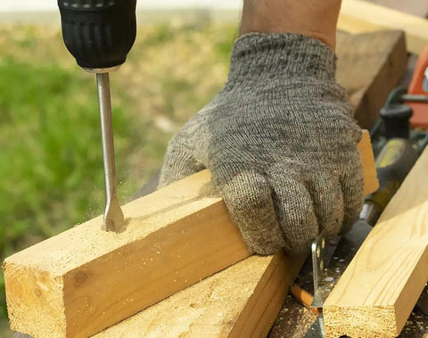 Person using 17 Piece SDS Plus Rotary Hammer Drill Bits And Chisels Set For Concrete And Masonry with gloved hand