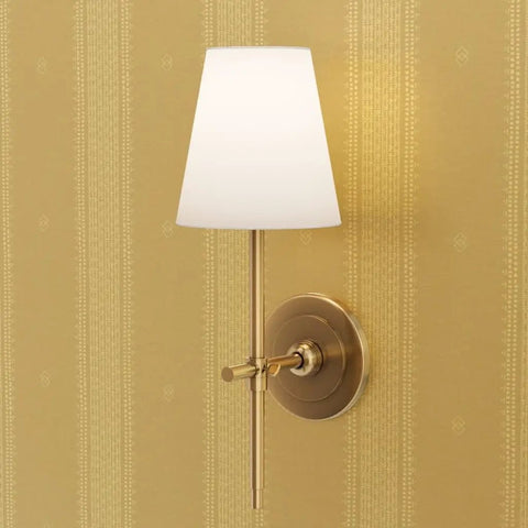 Hella Glam Farmhouse Stripe Gold Metallic Wallpaper With Textured Fibrous Grain Easy Glide Paste The Wall Covering Usa Crafted Eco Clean Next Level Shine Strips For Cozy American Homes Today with wall sconce and gold background.