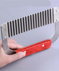 Side view of handheld stainless steel crinkle cutter with red wooden handle; ridged blade for slicing vegetables.