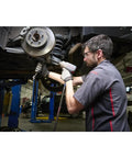 Mechanic using a Half Inch Drive Quiet Tech Air Impact Wrench With Up To 1300 Ft Lbs Torque For Pro Grade Assembly And Disassembly Perfect For Suspension Work And Industrial Equipment Repairs on a car suspension in a garage