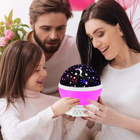 Family admiring Pink Star Projector Night Light For Kids Room Decor With A Cozy Dreamy Vibe For Girls Ages 3 4 5 6 7 8 9 10 Projects Up To 15 Feet Creating A Soft Eye Safe Starry Sky At Bedtime That Makes Bedtime A Little More Magical Gift Idea.