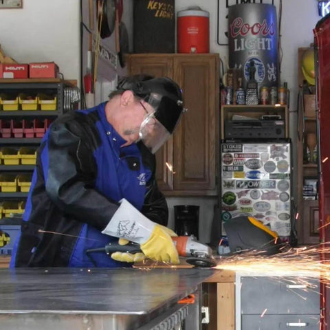 Person grinding metal wearing Elkskin Stick Glove With Nomex Lined Back, Extra Thick, Kevlar Stitching, Thumb Strap, Flame Resistant