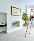 Person using a multi-position ladder with Cargo Hold Ladder Accessory Fabric Tool Pouch, equipped with pouches and slots in a domestic setting.