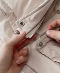 Ten Piece Tool Free Zipper Repair Kit For Backpacks Jackets And Clothes With Removable Universal Zipper Repairer Built For Easy Quick Fixes No Tool Needed Durable Metal Construction In Medium Size being used to fix a beige jacket zipper