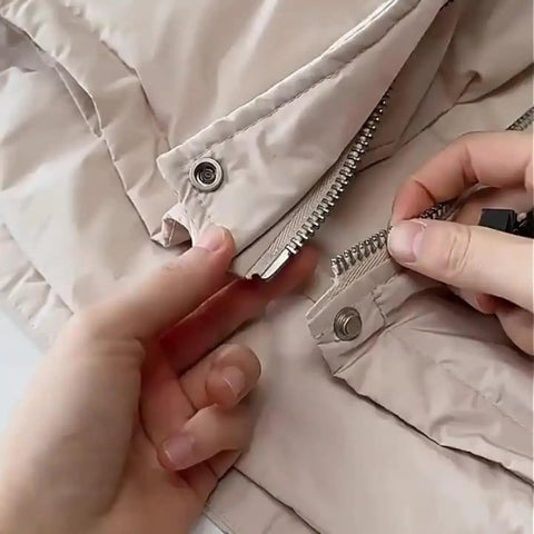 Ten Piece Tool Free Zipper Repair Kit For Backpacks Jackets And Clothes With Removable Universal Zipper Repairer Built For Easy Quick Fixes No Tool Needed Durable Metal Construction In Medium Size being used to fix a beige jacket zipper