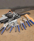 Assorted HVAC tools including Heavy Duty Metal Duct Folding Tool For HVAC, 24 X 3-Inch Duct Bender with gauges on a workshop floor.