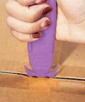 Safe Recessed Blade Box Cutter Knife 10 Pack Purple With Double Sided Blade For Easy Cuts And Reduced Risk Of Lacerations No Sweat For Opening Boxes Packages And Cartons in use on a cardboard box