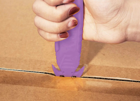Safe Recessed Blade Box Cutter Knife 10 Pack Purple With Double Sided Blade For Easy Cuts And Reduced Risk Of Lacerations No Sweat For Opening Boxes Packages And Cartons in use on a cardboard box