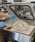 Heavy Hitter Chamber Vacuum Sealer With Rock Solid 1.5 Hp Rotary Oil Pump, sealing a turkey in a commercial kitchen.
