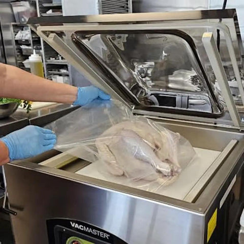 Heavy Hitter Chamber Vacuum Sealer With Rock Solid 1.5 Hp Rotary Oil Pump, sealing a turkey in a commercial kitchen.