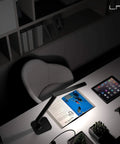 Super Handy Dimmable Led Desk Lamp with Four Lighting Modes in piano black illuminating a desk with tablet and book
