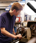 Person operating lathe with Foldable 2.55 Inch Crank Handle With Revolving Grip, compact handwheel in a workshop setting.