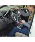 Person using Compact 12V Flexi Automotive Vacuum With 4 Ft Hose Crevice Tool 2in1 Wide Nozzle And Flip Up Brush Corded Handheld Car Vacuum For Tight Spaces And Quick Cleanups Built For On The Go Cleaning Motor In The Filter Tech in car interior