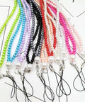 Colorful beaded lanyards with clasp ends, arranged neatly, showcasing various vibrant beads with attached black loops.