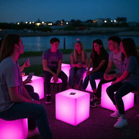 Group of friends sitting on glowing 16 Inch LED Cube Chair Light With 16 RGB Colors Glow Cube Seat at night