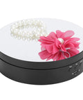 Spiffy Omquot Electric Rotating Jewelry Stand With 360 Degree Swivel Plate And Usb Charging Port For Watches Cosmetics And Toys In Sleek Black Finish with pearl bracelet and pink flower on mirror surface.
