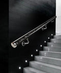 Sleek Transparent Acrylic Handrail With Heavy Duty Silver Wall Mount Brackets For Indoors Outdoors Stair And Deck Safety Featuring Bubble Design Supporting Four Hundred Forty Pounds Built Like A Tank For Daily Grind mounted on sleek black wall beside illuminated stairs.