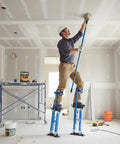 Man using Adjustable Drywall Stilts 24 To 40 Inch Professional Grade Aluminum Painter Stilt for painting ceiling in a room.