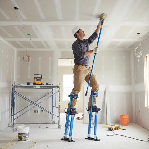 Man using Adjustable Drywall Stilts 24 To 40 Inch Professional Grade Aluminum Painter Stilt for painting ceiling in a room.