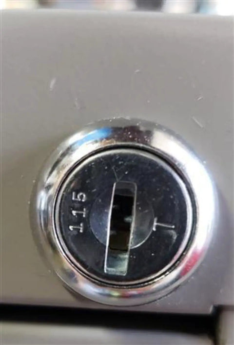Close-up of a locking mechanism on office furniture, showing the Custom Cut File Cabinet And Cubicle Desk Replacement Key functionality.