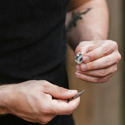 Man holding a V groove pulley and a small tool, showcasing the 20 Pack V Groove Pulleys For Gate Tracks With Deep Groove Ball Bearings Heavy Duty Wear Resistant Roller Bearings Smooth And Easy Slide Built Tough For Long Life V624zz.