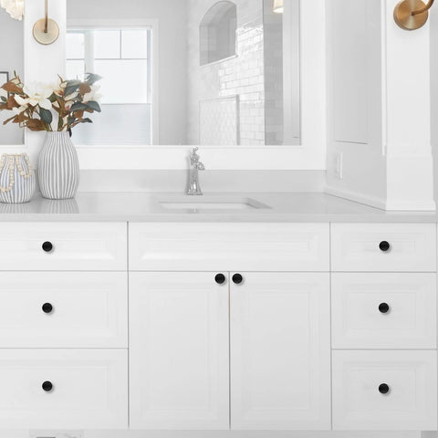 Matte black cabinet knobs on white bathroom cabinet, showcasing the 10 Pack 1-1/5 Inch (30mm) Cabinet Knobs Matte Black.