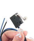 Black Waterproof Micro Switch With Roller Lever IP67 Sealed Limit Switch For Rugged Environments held in hand