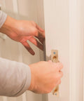 Hand operating Two Pack Aluminum Door Handle Pulls With Ergonomic Design And 128mm Hole Spacing on a sliding white door