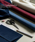 Assorted color fabric rolls with scissors, ruler, and pen on white surface, showcasing German craftsmanship and European quality.