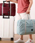 Person holding Foldable Travel Duffel Bag Set Two Pack Airline Friendly Carry On Luggage Weekender Tote For Women And Girls With Trolley Sleeve