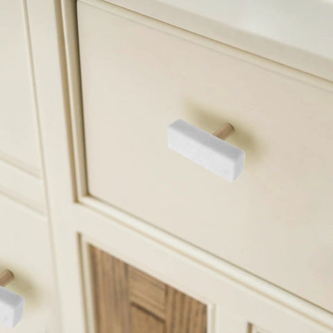 Sweet Finish T-Shaped Marble Cabinet Knobs With Brushed Brass Base, sharp drawer pull on light-colored dresser.
