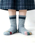 Person wearing repaired socks with patches from Complete Darning Kit With 14 Hook Mini Loom For Beginners Mushroom Patch Maker
