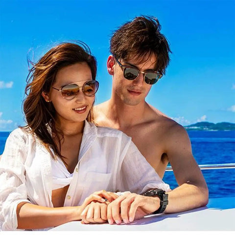 Couple on a boat with man wearing IQ-1204 DC Solar Link Dive Computer With Four Gas Mixes 21 To 100 Percent, solar rechargeable.